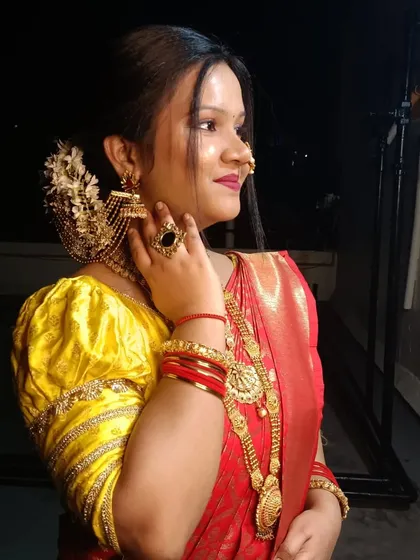 A side profile showcasing the elegant hairstyle with a gajra and the detailed jewellery. The makeup is glowing, perfect for an evening celebration.