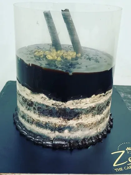 This is our interactive pull-me-up cake. When you lift the plastic collar, a rich layer of chocolate ganache cascades down the sides, creating a delicious waterfall effect over the layered cake.