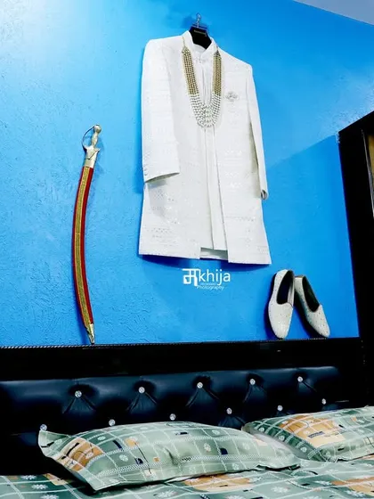 The groom's attire, ready and waiting. I often take detailed shots of the sherwani, shoes, and traditional accessories like the sword, as they are an important part of the wedding story.