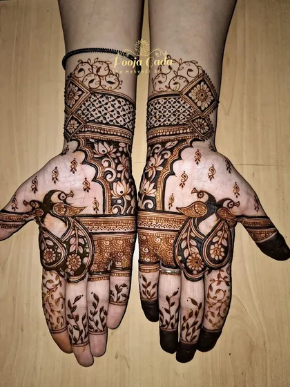 A unique siders design with artistic flair. The pattern features stylized peacocks with leafy vines on the fingers and a mix of geometric and floral work on the back of the hand.