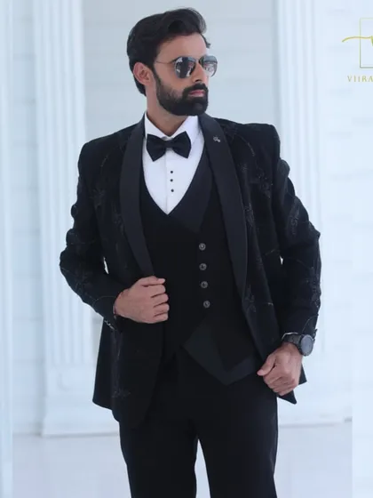 The three-piece construction of our black embroidered tuxedo is visible here. We can create suits with or without a waistcoat based on your style preference.