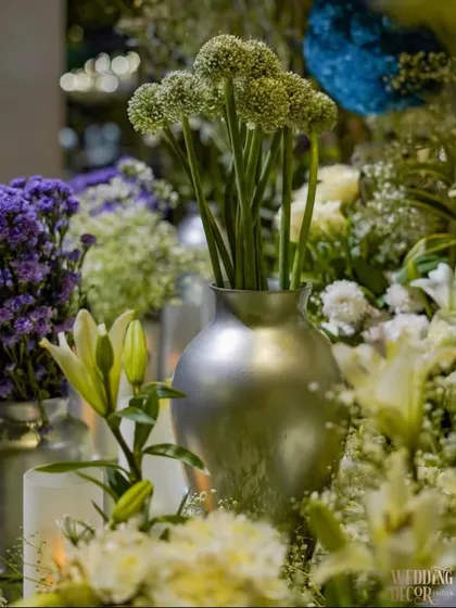 A mix of lilies, alliums, and other flowers in silver vases. The variety of shapes and textures in the floral arrangements added depth to the decor.
