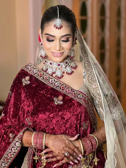 A detailed shot focusing on the intricate jewellery, from the ruby-studded choker to the matching maang tikka and earrings.