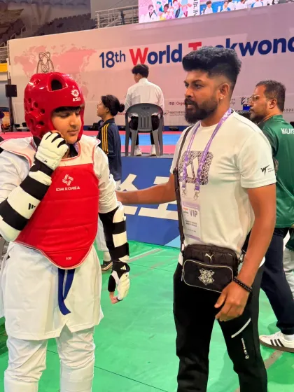 A quiet moment of strategy and encouragement with my student before he steps onto the mat for his bout at the international competition.