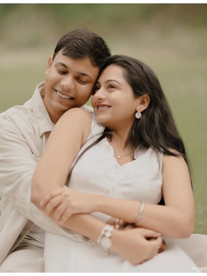 A tender embrace in a green meadow in Mussoorie. This close-up focuses on the couple's loving expressions and the soft, natural light.