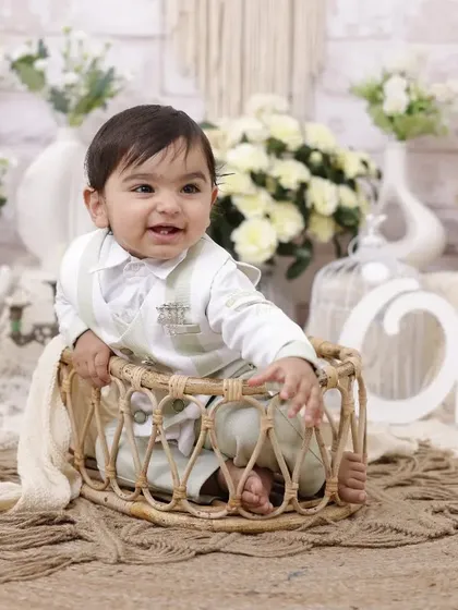 The joy of turning one is written all over his face. This happy shot from a first birthday session shows him in a wicker basket against our versatile rustic-chic studio backdrop.