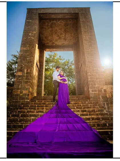 A grand, low-angle shot of the couple on stone steps, with the gown's long train creating a stunning visual.