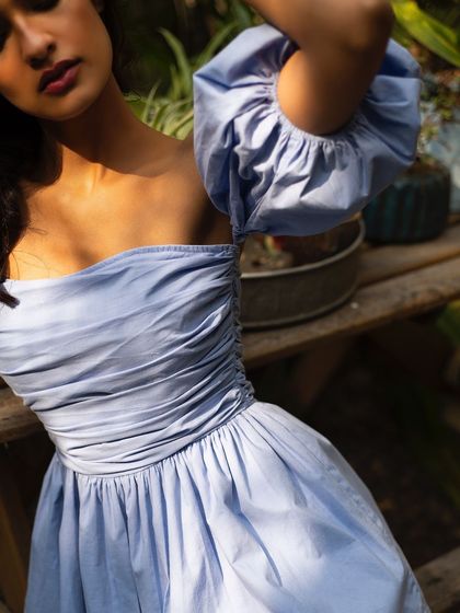 A detail shot of a beautiful blue summer top from It Girl, focusing on the ruching and fabric texture.