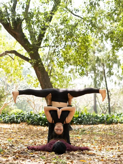 The same straddle throne pose with the flyer's hands in Anjali Mudra, adding a meditative element to the posture.