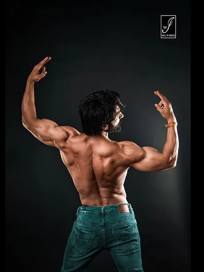 A wide back shot showcasing the full expanse of the latissimus dorsi muscles. My lighting setup is specifically designed to create deep shadows and bright highlights, revealing every detail of back development.