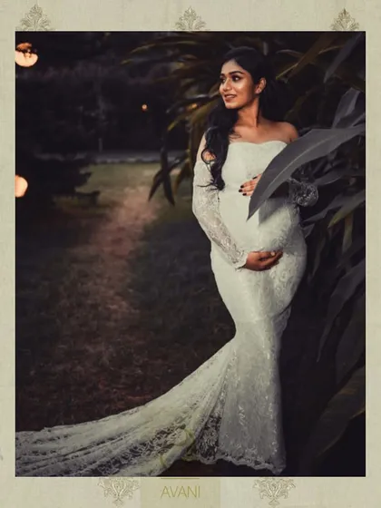 Another shot from the maternity shoot, showcasing the beautiful silhouette of the white lace gown against a garden backdrop.