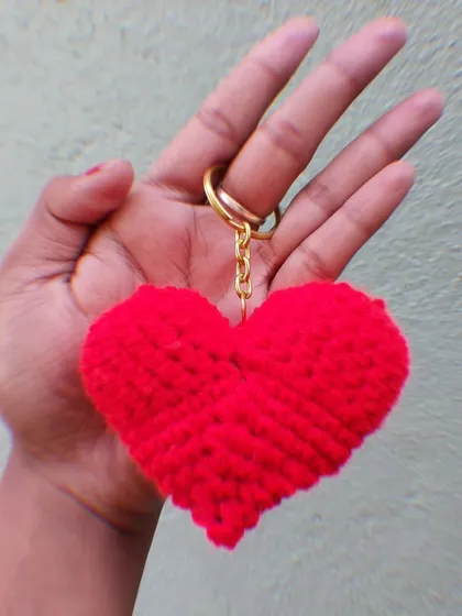 A plush red crochet heart keychain, perfect for Valentine's Day or as a gift for a loved one.