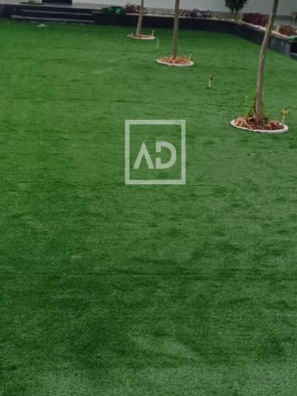 A large poolside area covered with artificial grass. It provides a soft, non-slip surface that stays green all year round without watering or mowing.