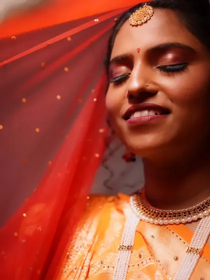 An ethereal shot of the bride through her veil, her eyes closed in a moment of quiet contemplation.