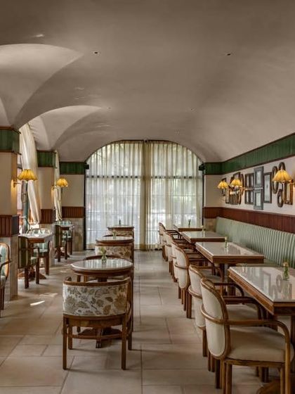 The long view of the cafe shows the rhythmic repetition of arches and the cozy banquette seating that runs along one wall.