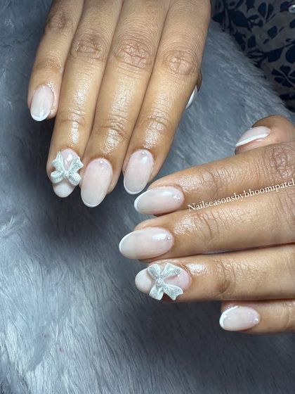 The 3D bow adds a beautiful and unique touch to this classic nude manicure.