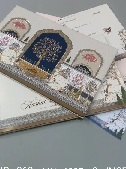 This invitation features a beautiful tree of life motif under a royal arch, with cows illustrated in the foreground. The design is unique and rooted in Indian cultural art.