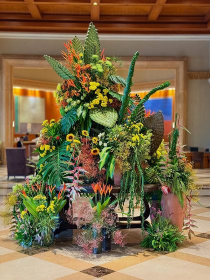 This grand floral masterpiece is filled with vibrant sunflowers and lush greenery. It's designed to elevate the hotel lobby's ambiance, making it feel like a tropical paradise.