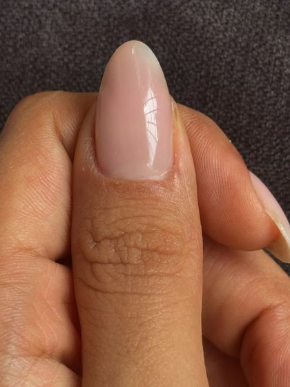 A perfect, glossy thumb nail showing the beauty of the simple soap nail trend.