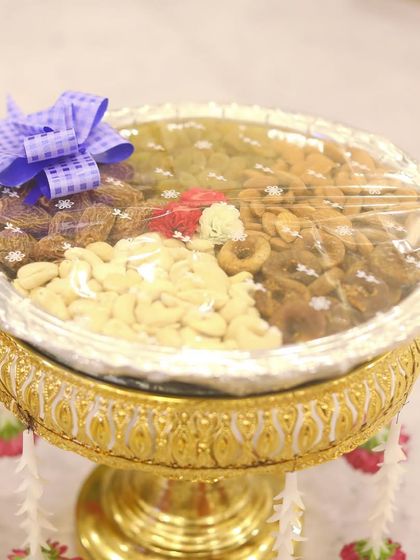 A close-up of a dry fruit plate decoration. A healthy and beautiful addition to the traditional offerings, this plate includes cashews, raisins, and other nuts.