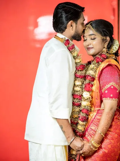 A romantic shot of the couple. The groom's kiss on her forehead is a sweet moment, and her makeup looks perfect.