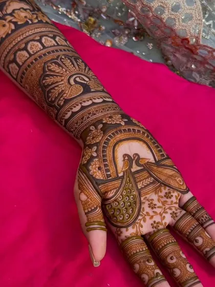 The palm of this design features two peacocks inside an arch, a classic element of traditional Indian art.