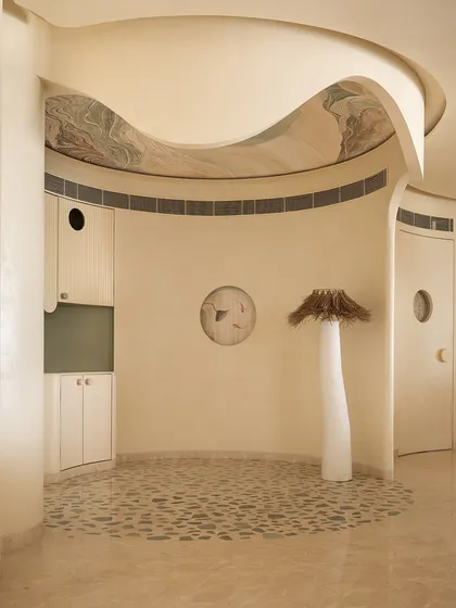 This coffee corner is an ode to our client's love for coffee. The floor features quartzite chips inlaid in a terrazzo pattern, while a sculptural floor lamp and art on the ceiling complete this unique, cozy nook.
