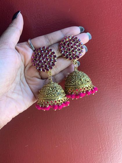 Various shots of the large pink stone stud jhumkas, showcasing their sparkle and rich color against different backdrops.