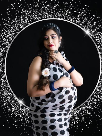 A glamorous take on the saree portrait. The mom-to-be wears a polka dot saree, framed by a sparkling silver ring against a black background for a modern, celebratory feel.