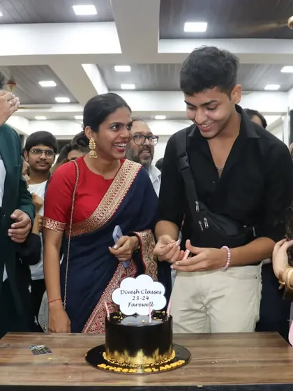 A student and teacher share a happy moment during the cake cutting at the farewell party.