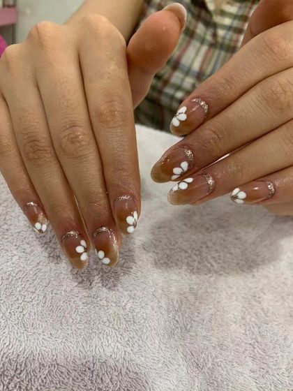 A cute and simple design with hand-painted white daisies on a sheer brown base with a touch of silver glitter.