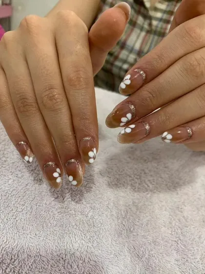 A sweet and simple design with a sheer brown base, accented with small white daisies and a touch of silver glitter.