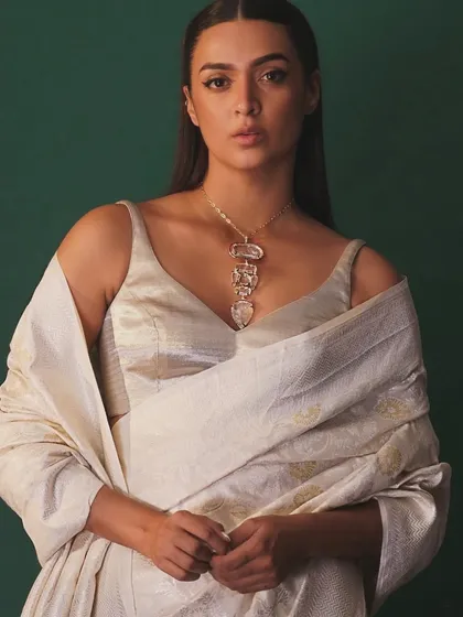 A frontal view of the handwoven saree and carved necklace, showing how the ensemble drapes beautifully to create a look of quiet luxury.