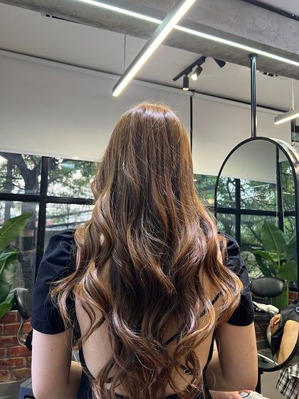 The same absolute brown hair, showing how the waves and layers work together to create a full and dynamic style.