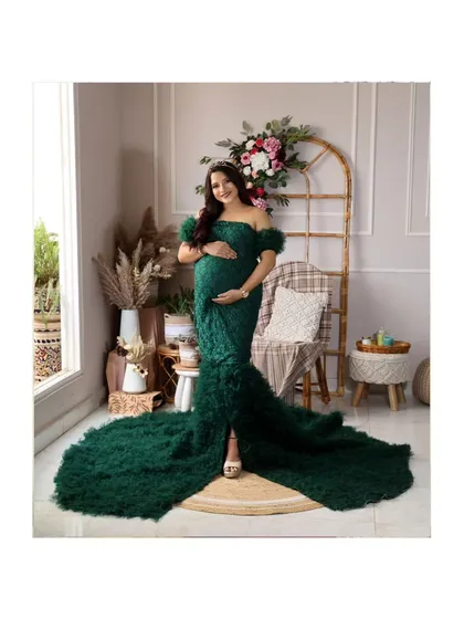 Another beautiful angle of the green gown, showcasing its elegant off-the-shoulder design and feathered texture.