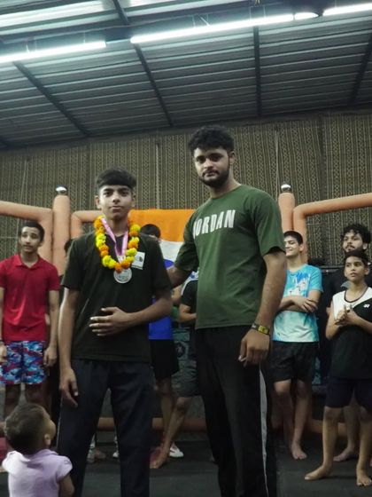 A young fighter is honored by his teammate after a successful competition. We build each other up.