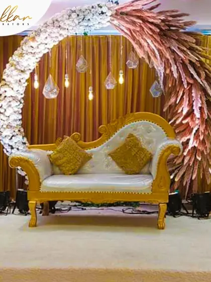 A modern and artistic reception stage. The semi-circular arch is decorated with white flowers and dried pampas grass, creating a unique and stylish backdrop.