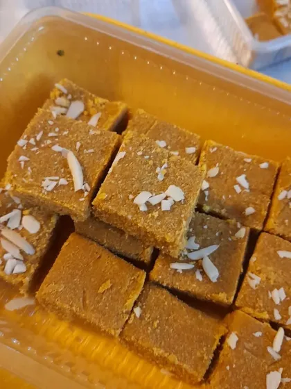 A close-up of the Besan Barfi, showing the rich texture and generous almond topping. It's a classic sweet that I make with great care.