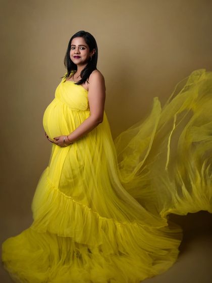 The flowing train of this yellow gown adds beautiful movement to the portrait. I will help you pose to best showcase the elegance of the dress and your baby bump.