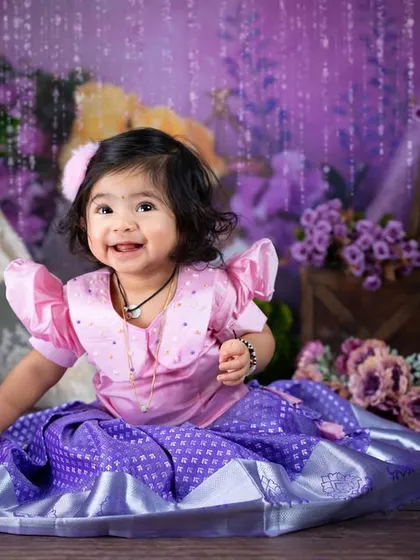 A bright, happy smile that lights up the room. The sparkling curtain in the background adds a touch of magic to this traditional portrait.