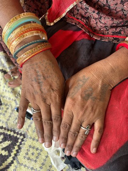 The hands of Mumal, one of our embroidery artisans in Barmer, Rajasthan. The traditional tattoos, known as 'trajva', hold deep cultural significance and are markers of identity and heritage.