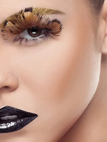 Another artistic crop of the avant-garde beauty look. This composition highlights the contrast between the dark lipstick and the detailed feather work around the eye.