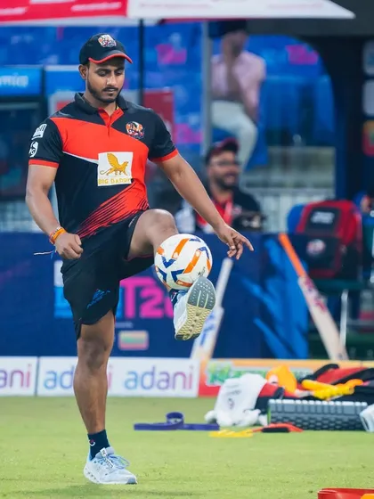 A close-up of me juggling a football on the field. This is a great way to stay sharp, improve balance, and keep the warm-up engaging and fun.