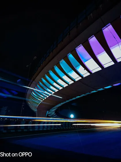 This long-exposure shot for an Oppo contest uses multi-colored lights on a bridge to create a dynamic and colorful image. The light trails from traffic add a sense of speed and energy.