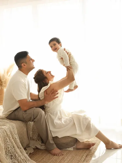 A flight of joy. The pure happiness in this photo, as a mother lifts her child, is infectious. The bright, high-key lighting creates a dreamy and ethereal feel, focusing on the love and connection.