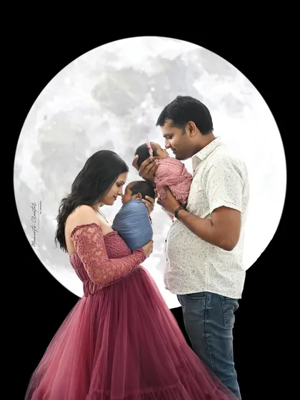 A family portrait under the moon. The proud parents hold their twin newborns, creating a magical and unforgettable first family photo.