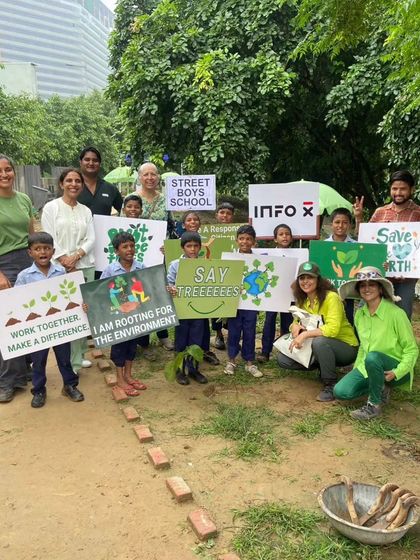 Students from the Street Boys School pose with their signs after a rainy but joyful plantation drive at Aravali Creek.