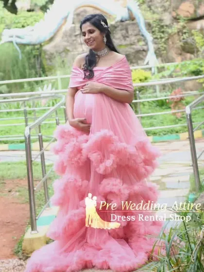 Our popular pink ruffled gown, captured from another angle to show its flattering off-the-shoulder neckline and voluminous skirt. A perfect choice for a classic and beautiful maternity shoot.