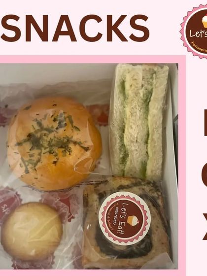 This box contains a chutney sandwich, a savoury bun, a slice of marble cake, and a cookie, offering a delightful mix for a tea-time event.