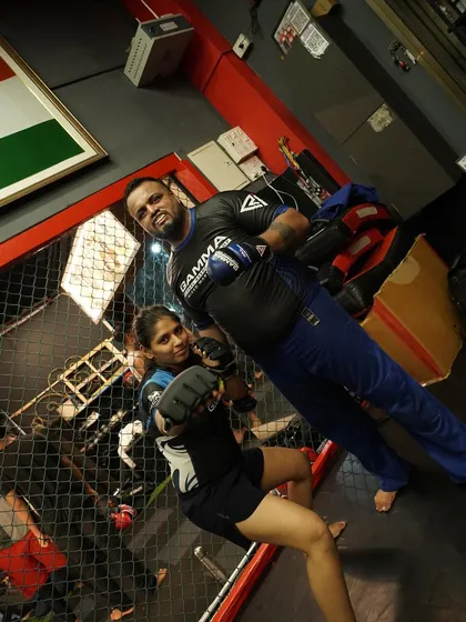 You are a warrior, a fighter, a force of nature. Here, one of our female fighters trains inside the cage, a testament to her strength and determination.
